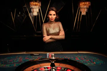 A woman smiling by bright slot machines showing lucky symbols, showcasing the exciting slot offerings at CROWNBD.